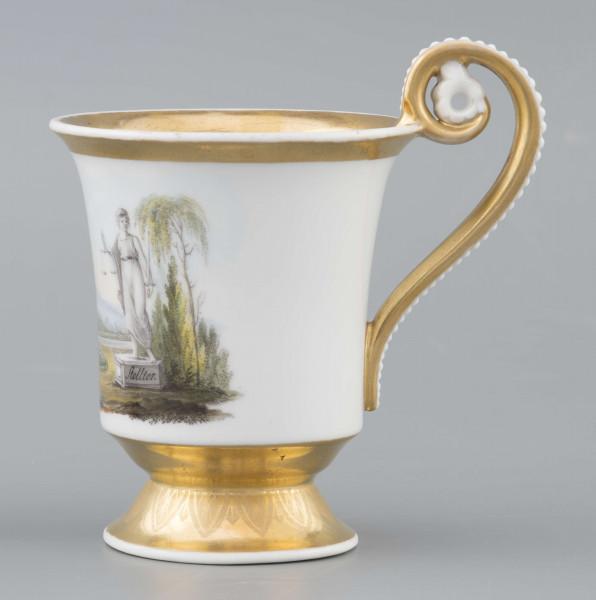 S/CS/1583/ML - Filiżanka koniczna, wylew lekko wywinięty, stopa w kształcie ściętego stożka, ucho wyciągnięte ponad wylew z rozetą  w górnym osadzeniu i wzorem perełek na powierzchni. Dekoracja malowana wielobarwnie: frontalnie na białym tle miniatura ze sceną parkową: od lewej drzewo, para spacerująca wokół gazonu, w głębi daleki pejzaż, na prawo stojąca rzeżba - personifikacja Sprawiedliwości z podpisem na cokole 