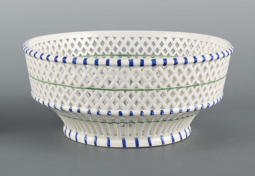 S/CS/1371/ML - Kosz konicznie wgłębiony, kołnierz ażurowy - w dolnej części pionowe równoległe pręty, w górnej ukośna kratownica), wylew obwiedziony półwałkiem. Dekoracja malowana barwnie: lustro obwiedzione wicią winorośli z trzema gałązkami niezapominajek, elementy koszykowe konturowane zielenią, krawędzie od zewnątrz podkreślone błękitnymi pionowymi kreskami.  