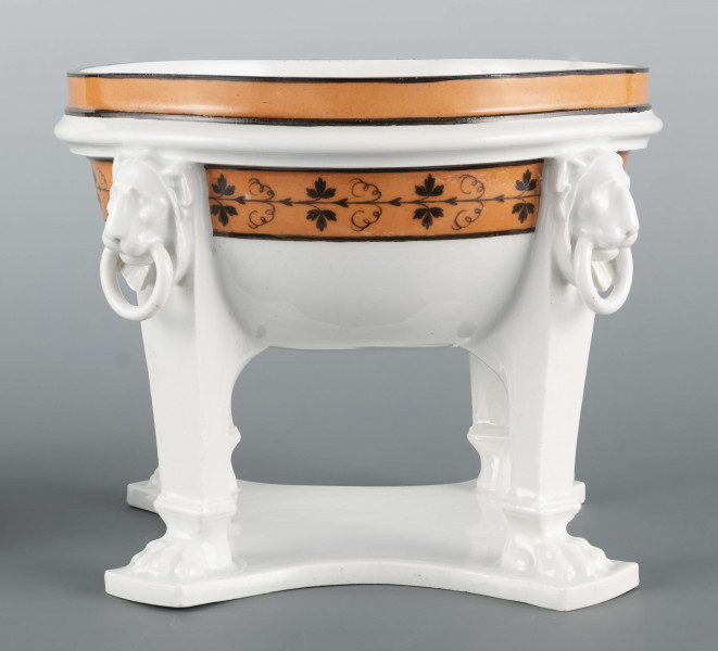 S/CS/1226/ML - Półkulista czasza wsparta na czterech podporach przymocowa- nych do płaskiej wielobocznej podstawy. Podpory u nasady zakończone lwimi łapami, w zwieńczeniu antabami z lwimi maskami. Wylew obwiedziony jest cynobrową bordiurą z czarnymi konturami, czaszę obiega fryz czarnej winorośli na cynobrowym tle. Brak pokrywy
 