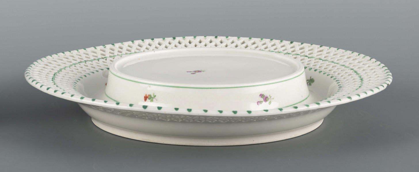 S/CS/1371/ML - Kosz konicznie wgłębiony, kołnierz ażurowy - w dolnej części pionowe równoległe pręty, w górnej ukośna kratownica), wylew obwiedziony półwałkiem. Dekoracja malowana barwnie: lustro obwiedzione wicią winorośli z trzema gałązkami niezapominajek, elementy koszykowe konturowane zielenią, krawędzie od zewnątrz podkreślone błękitnymi pionowymi kreskami.  