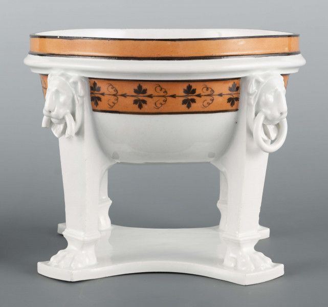 S/CS/1226/ML - Półkulista czasza wsparta na czterech podporach przymocowa- nych do płaskiej wielobocznej podstawy. Podpory u nasady zakończone lwimi łapami, w zwieńczeniu antabami z lwimi maskami. Wylew obwiedziony jest cynobrową bordiurą z czarnymi konturami, czaszę obiega fryz czarnej winorośli na cynobrowym tle. Brak pokrywy
 