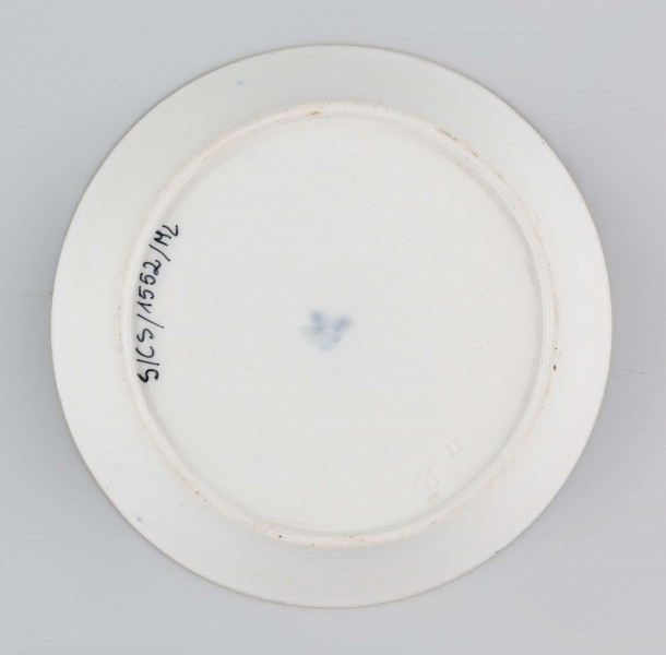 S/CS/1552/ML - Spodek okrągły, konicznie wgłębiony, powierzchnia malowana kobaltem podszkliwnie na ciemno-błękitny kolor, na nim bogata dekoracja w wypukłym złocie ułożona w koncentryczne kręgi z rozetą pośrodku i meandrem na kołnierzu. Pomiędzy pasami złotymi ornamentalne wstęgi malowane jasnobłękitnym kolorem ze złotymi dodatkami.
 