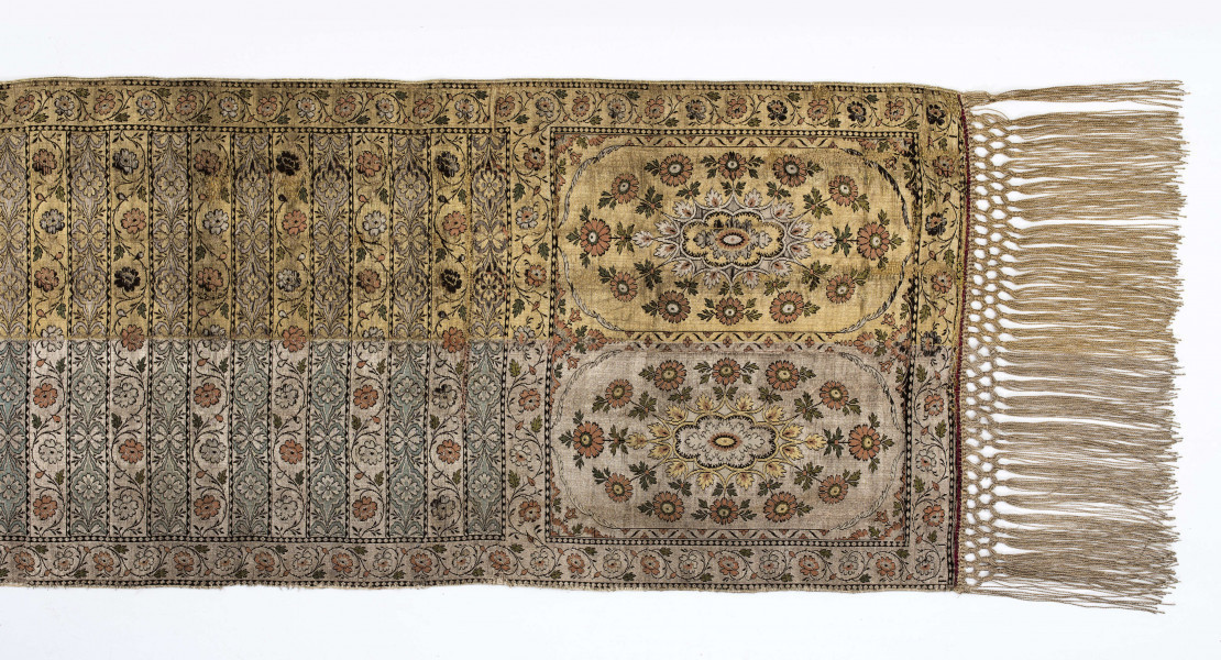 Pas kontuszowy czterostronny.
Ornament:
głowy - dwa motywy ukwieconych rozet wpisanych w owalne medaliony
środek - poprzeczne pólka na przemian z motywami wici kwiatowej i połączonych rozet, obrzeżenia pionowe i poziome z wicią jak w pólkach
obwódki - w trójkąciki
Kolor:
tło - w połowie srebrne, w połowie złote
ornament - kwiaty jasnoczerwone w głowach, w pólkach na przemian jasnoczerwone i białe, listki zielone, gałązki i trójkąciki czarne
strona lewa w połowie zielona w połowie czerwona
Frędzla wiązana, doszyta, w połowie srebrna, w połowie złota
Sygnatura wytkana w narożnikach obu głów: 