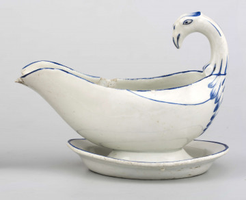 Sosjerka łódkowata z szerokim lekko wywiniętym wylewem, uchwyt w formie stylizowanej głowy łabędzia, zespolona z podstawka w formie owalnego talerzyka o podniesionym lustrze. Krawędzie i rusunek głowy ptaka podkreślone błękitnym konturem.
 