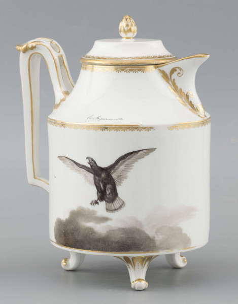 S/CS/1480/ML - Dzbanek cylindryczny, na trzech nóżkach w kształcie lwich łap, szyja w formie zwężonego pierścienia, wylew z dziobkiem, ucho dołem prostokątnie załamane, górą wygięte, rozdwojone, z reliefowymi liśćmi w osadzeniach. Przykrywa w formie wąskiego, konicznego pierścienia, z uchwytem w kształcie szyszki. Dekoracja drukowana en grisaille w kolorze czarnym. Po obu stronach brzuśca sceny alegoryczne: lew prowadzony na pasku przez amorka, powyżej napis 