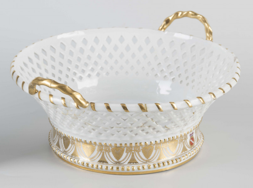 S/CS/40/ML - Kosz okrągły na pełnej podstawie wyodrębnionej dwoma wałkami , ścianki koniczne, ażurowew postaci plecionki koszykowej, z dwoma zaokrąglonymi uchami umocowanymi pionowo do górnej krawędzi. Podstawę obiega złocony fryz złożony ze stylizowanych pionowych palmet połączonych z giętymi liniami i girlandami perełek. W miejscu jednej palmety malowana okrągła tarcza z herbem Szreniawa pod  mitrą książęcą. Ucha złocone, złotem podkreślone krawędzie.
 