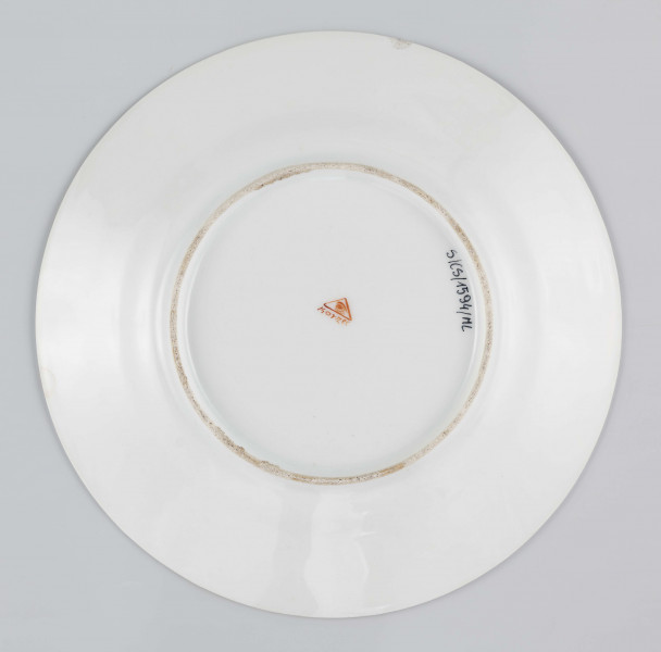 S/CS/1594/ML - Talerz płytki, okrągły, gładki. Na kołnierzu fryz z ornamentu palmetowego przeplecionego barwnymi elementami: kaduceuszem, wężem Eskulapa, monogramem 