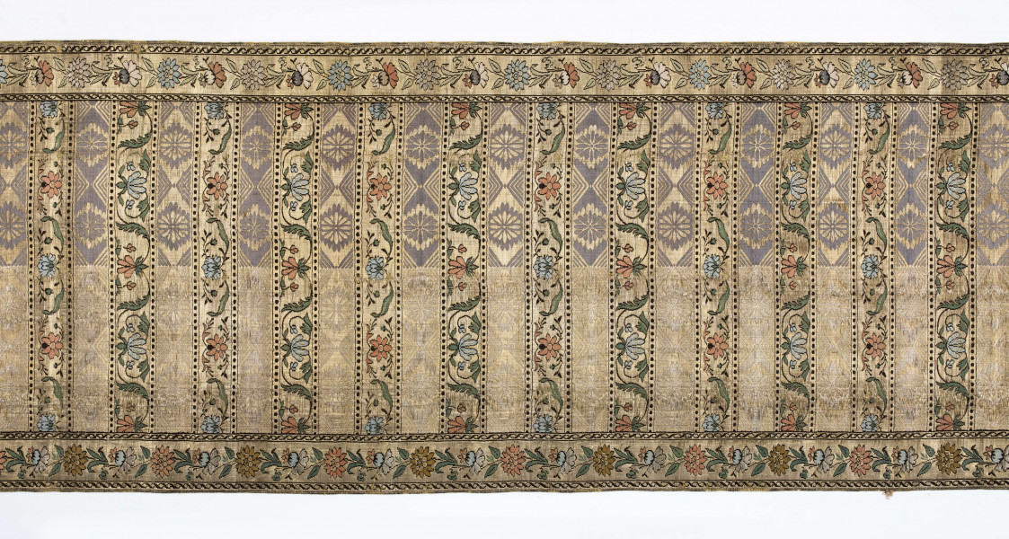 Pas kontuszowy 4-stronny
Ornament:
głowy - dwa motywy ukwieconych rozet wpisanych w owalne medaliony
środek - poprzeczne pólka w układzie a,b,a,c
a - z motywem rombów z rozetami
b i c - z dwoma odmiennymi motywami zgeometryzowanej wici kwiatowej
obrzeżenia - z motywem gałązek kwiatowych 
obwódki pionowe w przeplatające się wężyki, poziome w kółeczka
Kolor:
pr. - tło złote, ornement  - kwiaty w głowach i pólkach b, c, na przemian łososiowe i jasnoniebieskie, listki zielone, gałązki i kontury czarne, romby w pólkach a w połowie niebieskie, w połowie białe
l. - tło czarne, pólka a w połowie czerwone, w połowie zielone, 
Frędzla doszyta, pleciona, złota
W narożnikach sygnatura wytkana w prostokącie: 