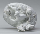 S/CS/1456/ML - Grupa figuralna z białej szkliwionej porcelany. Cokół owalny, wysklepiony z ornamentem opaskowym złożonym ze splecionych owali z rozetkami. Na nim siedzi naga kobieta (Venus) przed płonącym stosem o wysokich płomieniach i wyciągniętą w bok prawą ręką powstrzymuje nagie dziecko (Amorek) zapalające od ognia pochodnię, lewą ręką siega do ażurowego naczynia z ogniem. Za nią na powierzchni cokołu drobne roślinki.
