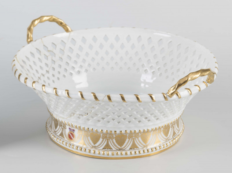 S/CS/40/ML - Kosz okrągły na pełnej podstawie wyodrębnionej dwoma wałkami , ścianki koniczne, ażurowew postaci plecionki koszykowej, z dwoma zaokrąglonymi uchami umocowanymi pionowo do górnej krawędzi. Podstawę obiega złocony fryz złożony ze stylizowanych pionowych palmet połączonych z giętymi liniami i girlandami perełek. W miejscu jednej palmety malowana okrągła tarcza z herbem Szreniawa pod  mitrą książęcą. Ucha złocone, złotem podkreślone krawędzie.
 