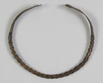 1396/A/ML/4 - Naszyjnik brązowy wykonany z czworograniastego pręta skręconego dookoła swej osi. Oba kóńce naszyjnika spłaszczone i nadkruszone. Naszyjnik bardzo silnie wytarty od dłuższego używania. 