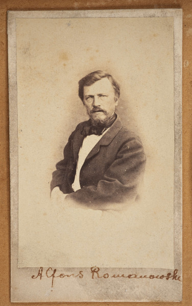 Tableau szklone zewnętrznie, w ramie, zawiera na tekturowym podłożu 15 fotografii uczestników powstania z terenu Wołynia. Pośrodku brak jednej, większej fotografii. Zdjęcia wykonane w sepii, w formacie pocztówkowym, niektóre z nich są podpisane pod spodem i na odwrociu: Eugeniusz Rdułtowski, Herkulan Kardussowski, F. Boryczewski, Antoni Straszewicz, Alfons Romanowski, Adam Hreczyna, Jan Grabis, Antoni Szymkiewicz.
Niektóre fotografie mają na kartonikach wyciskane napisy w języku rosyjskim. W środku tableau, pod pierwszym rzędem zdjęć przymocowany krzyżyk wykonany z chleba i tabaki, dekorowany motywem różyczek. Nad krzyżykiem druciana korona cierniowa, na niej krzyżyk z metalu z gałązką palmową. Niżej, pod brakującą fotografią lufka (?) z tektury, pierścionek i mały medalion ze Świętą Rodziną. Poniżej przymocowany grzebień rogowy, jakucki z napisem w języku rosyjskim i datą: 1864. Całość w ozdobnej ramie z dekoracyjnymi narożnikami, koroną, herbami Polski, Litwy, herbem z literą S. 