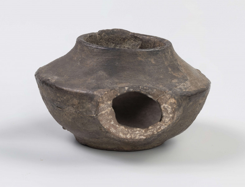 720/A/ML/1 - Lampka oliwna z utłuczonym uszkiem i dziubkiem na płomień; ostro profilowana z dużym otworem do wlewania oliwy zakończonym niewielką cylindryczną szyjką; dno lekko wklęsłe, wyodrębnione niewielka stopką; lampka tzw. a szuf - palona na tłuszcz zwierzęcy - Fibellampen; popularny typ całego świata antycznego
wymiary dodatkowe: 3,7 cm (śr. dna)