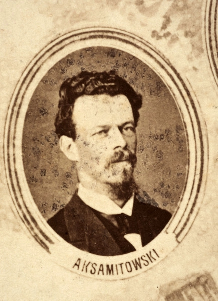 Fotografie w odcieniu sepii umieszczone na tle drzew i roślin, w centralnym miejscu postać kobiety ze sztandarem i aniołkami, wkomponowane widoki budowanej stacji, mostu kolejowego i lokomotywy. Największe zdjęcie w górnej, środkowej części bez podpisu, prawdopodobnie inż. głównej kolei nadwiślańskiej Tadeusz Chrzanowski lub jego następca Walery Titkow. Wśród podobizn pracownicy Biura Głównego Inżyniera: inż. Włodzimierz Stanisławski - pomocnik głównego inżyniera; inż. Feliks Kucharzewski -  pomocnik naczelnika biura; Feliks Kamocki - naczelnik kancelarii; Witold Lanci - naczelnik Wydz. Architektury; dr Wacław Lasocki- służba zdrowia; Władysław Radwan - sprawy zakupu gruntów; inż. Stanisław hr Scipio - projektant mostów kolejowych i jego współpracownicy: inż. Stefan Zieliński, inż. Maurycy Machalski, inż. Feliks Kucharzewski. Fotografia w passe - partout, za szkłem, oprawiona w drewnianą, profilowaną ramę.