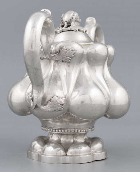 S/Mt/392/ML - Stopa ośmiolistna z ośmioma wydatnymi puklami; trzon krótki zdobiony rzedem perełek; korpus gruszkowaty pokryty dwoma rzędami pukli w formie kropel - większe na dole, mniejsze u góry; po bokach dwa ucha w formie litery 