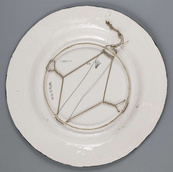 S/CS/1213/ML - Pólmisek pokrągły, gładki, szkliwiony, dekoracja malowana wielobarwnie. W lustrze malowane popiersie króla w koronie zamkniętej i zbroi, nad głową napis majuskułą w czarnym kolorze: KAZIMIERZ SPRAWIEDLIWY. Na kołnierzu fryz z liściasto-wolutowej girlandy, wilobarwnej, na ciemnobłękitnym tle.   
