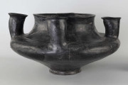 598/A/ML - naczynie kultowe (kernos) kultury pomorskiej; 
wymiary dodatkowe: 25,0 cm - średnica centralnego wylewu
opis: naczynie wazowate o czarnej, błyszczącej powierzchni, którego brzusiec został ozdobiony ornamentem złożonym z linii rytych oraz nakłuć; wokół głównego otworu posiada cztery symetrycznie rozmieszczone kielichy-rytony, które mają nieco wydęte ścianki boczne i kielichowato rozchylone na zewnątrz krawędzie otworów; rytony łączą się z głównym otworem kanalikami; 