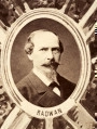 Fotografie w odcieniu sepii umieszczone na tle drzew i roślin, w centralnym miejscu postać kobiety ze sztandarem i aniołkami, wkomponowane widoki budowanej stacji, mostu kolejowego i lokomotywy. Największe zdjęcie w górnej, środkowej części bez podpisu, prawdopodobnie inż. głównej kolei nadwiślańskiej Tadeusz Chrzanowski lub jego następca Walery Titkow. Wśród podobizn pracownicy Biura Głównego Inżyniera: inż. Włodzimierz Stanisławski - pomocnik głównego inżyniera; inż. Feliks Kucharzewski -  pomocnik naczelnika biura; Feliks Kamocki - naczelnik kancelarii; Witold Lanci - naczelnik Wydz. Architektury; dr Wacław Lasocki- służba zdrowia; Władysław Radwan - sprawy zakupu gruntów; inż. Stanisław hr Scipio - projektant mostów kolejowych i jego współpracownicy: inż. Stefan Zieliński, inż. Maurycy Machalski, inż. Feliks Kucharzewski. Fotografia w passe - partout, za szkłem, oprawiona w drewnianą, profilowaną ramę.