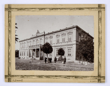 Gmach Towarzystwa Kredytowego Ziemskiego przy ul. Krakowskie Przedmieście w Lublinie. Widok od strony brukowanej ulicy. Piętrowy murowany budynek. Nad głównym wejściem wsparty na czterech kolumnach balkon z balustradą. Część środkowa lekko wysunięta, zwieńczona cokołem z rzeźbą (trzy postacie kobiece). Okna piętra dekorowane trójkątnymi tympanonami. Pomiędzy nimi pilastry. Część parterowa boniowana. Na frontowej elewacji napis w języku polskim i rosyjskim. Przed budynkiem kilka drzew, stojąca latarnia oraz grupa pięciu osób. Po prawej fragment ogrodzenia i boczna elewacja z oknami.
Fotografia sepiowana, naklejona na tekturę, otoczona ozdobną ramką w kolorze złotym w formie przecinających się na rogach listew. W l. d. rogu nazwisko autora fotografii, w p. d. nazwa miasta. Na rewersie odbitki pieczęci tuszowych Muzeum Nałęczowskiego (okrągła, w kolorze fioletowym) oraz Biblioteki Nałęczowskiej (podłużna, w kolorze fioletowym), a także odręczny napis czarnym tuszem z opisem fotografii.
