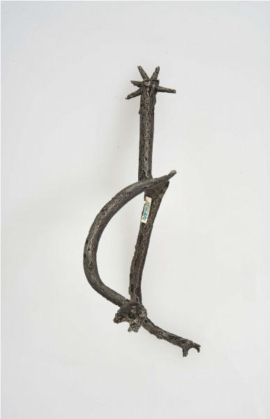 Ostroga żelazna w kształcie wideł z półkoliście wygiętymi ramionami zakaończonymi gwiazdkami; kolec również zakończony gwiazdką umocowaną przez włożenie jej w rozszczepiony kolec i przewleczono nitem