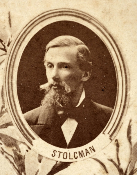 Fotografie w odcieniu sepii umieszczone na tle drzew i roślin, w centralnym miejscu postać kobiety ze sztandarem i aniołkami, wkomponowane widoki budowanej stacji, mostu kolejowego i lokomotywy. Największe zdjęcie w górnej, środkowej części bez podpisu, prawdopodobnie inż. głównej kolei nadwiślańskiej Tadeusz Chrzanowski lub jego następca Walery Titkow. Wśród podobizn pracownicy Biura Głównego Inżyniera: inż. Włodzimierz Stanisławski - pomocnik głównego inżyniera; inż. Feliks Kucharzewski -  pomocnik naczelnika biura; Feliks Kamocki - naczelnik kancelarii; Witold Lanci - naczelnik Wydz. Architektury; dr Wacław Lasocki- służba zdrowia; Władysław Radwan - sprawy zakupu gruntów; inż. Stanisław hr Scipio - projektant mostów kolejowych i jego współpracownicy: inż. Stefan Zieliński, inż. Maurycy Machalski, inż. Feliks Kucharzewski. Fotografia w passe - partout, za szkłem, oprawiona w drewnianą, profilowaną ramę.