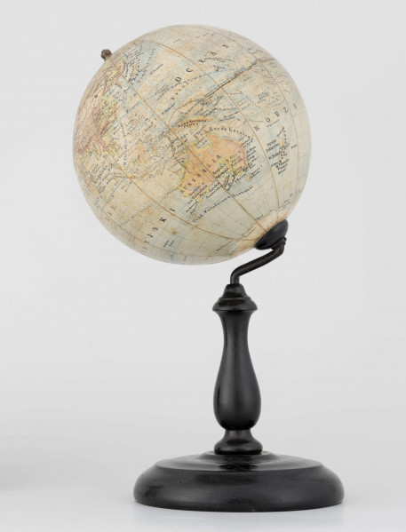 Globus fizyczno-polityczny Ziemi w skali 1:80 mln, litografia kolorowa; 12 segmentów, z polską nomenklaturą; południk zerowy biegnie przez Greenwich. Kula tekturowa, postument drewniany toczony, ramię metalowe, bez południka. Na globusie obie Ameryki, Azję i Australię otoczono czerwoną wstęgą, Afrykę - niebieską, Europa - zielono-żółtą. 