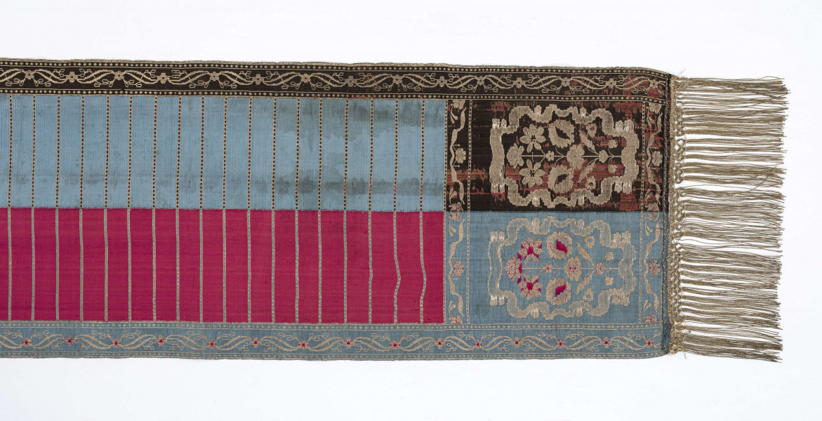 Pas kontuszowy 4-stronny
Ornament:
głowy - dwa krzaczki kwiatowe otoczone medalionami z wijącej się wstęgi
środek ( wciąż)- poprzeczne gładkie pólka
obwódki - z motywem kostki i rombów
obrzeżenia pionowe z motywem podwójnej przeplatającej się wici roślinnej, poziome - z motywem wijacej sie wstążki z kwiatami
Kolor:
pr. - tło głów i obrzeżeń srebrne, ornament brązowy z błękitem i amarantem, pólka w połowie brązowe (czarne ?), w połowie kremowe
l. - tło połowy głów i obrzeżeń błękitne oraz  w połowie pólek amarantowe, druga połowa głów i obrzeżeń brązowa oraz pólek - amarantowa
W narożnikach sygnatura wytkana 