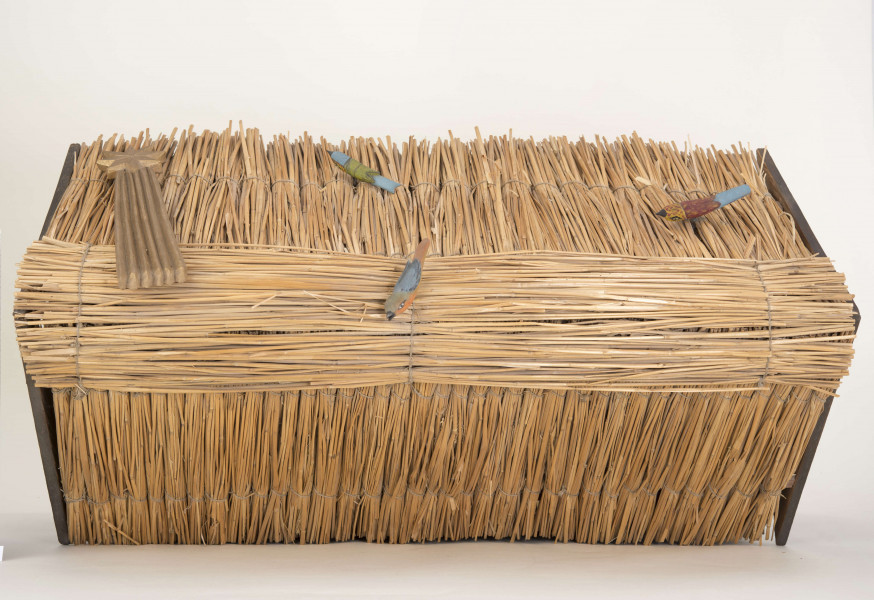 Szopka kolędnicza. Dach dwuspadowy. Na poszyciu dachu figurki trzech drewnianych kolorowych ptaszków. W szopce znajduje się 9 figurek drewnianych przedstawiających postaci ludzkie i żłóbek oraz figurki: osła, wołu i baranka. Pośrodku szopki stoi żłóbek z Dzieciątkiem, po lewej stronie postać Matki Boskiej (wys. 22 cm), po prawej – postać św. Józefa (wys. 22 cm). Za żłóbkiem z tyłu postać Anioła (wys. 21 cm). Przed żłóbkiem figurka przedstawiająca baranka. Z lewej strony wzdłuż ściany figurki trzech króli. Pierwszy król (wys. 16 cm) – murzyn, trzyma w rękach złotą kulę, drugi (wys. 21,5 cm) – złoty domek, trzeci (wys. 22 cm) – złotą księgę. Z prawej strony wzdłuż ściany znajdują się: mężczyzna (wys. 23 cm) w lewej ręce trzymający laskę, a w prawej worek, kobieta (wys. 21 cm) z kurą w rękach oraz – pomiędzy figurkami wołu i osiołka, postać mężczyzny grającego na trąbce. 
Figurki z drewna lipowego, polichromowane.