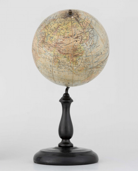Globus fizyczno-polityczny Ziemi w skali 1:80 mln, litografia kolorowa; 12 segmentów, z polską nomenklaturą; południk zerowy biegnie przez Greenwich. Kula tekturowa, postument drewniany toczony, ramię metalowe, bez południka. Na globusie obie Ameryki, Azję i Australię otoczono czerwoną wstęgą, Afrykę - niebieską, Europa - zielono-żółtą. 