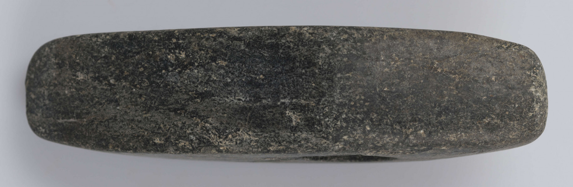 530/A/ML - Topór kamienny wykonany z czarnego kamienia, starannie gładzony. Kształt dwustożkowaty, przekrój czworokątny. Barwa czarna.
wymiary dodatkowe: 1,8 cm (średn. otworu)