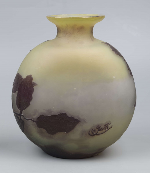 S/CS/1378/ML - Wazon w formie kuli pionowo spłąszczonej z krótką szyją i owalnym wylewem, szeroko wywiniętym, z płasko sciętym brzegiem; ze szkła bezbarwnego, matowionego, przy dnie i przy szyi barwionego na kolor żółty i fioletowobrunatny. Na powierzchni plastyczny wzór swobodnie rzuconej gałązki klematisu z kwiatami w kolorze fioletowobrunatnym.
 