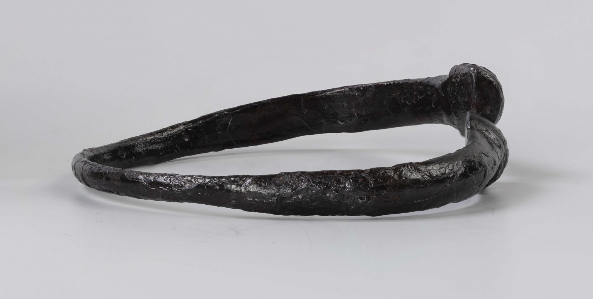 824/A/ML/1 - Żelazna bransoleta ze stylizowanymi wężowymi główkami. W części środkowej przekrój trapezowaty, przy główkach trójkątny.