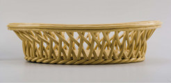 Koszyczek owalny głęboki; dno pełne od zewnątrz obwiedzione warkoczem, boki z okrągłych wałków przeplecionych ukośnie, połączonych profilowaną obręczą tworzącą krawędź. W lustrze (na dnie) dekoracja reliefowa: pośrodku bukiet kwiatów w wazonie, wokół brzegu wić laurowa z owocami. Całość pokryta połyskliwą glazurą w kolorze jasnego ugru.
 
