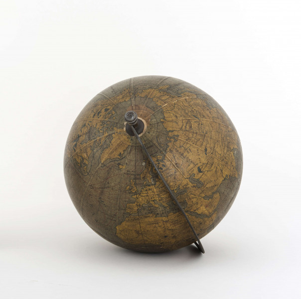 Globus bez tytułu, roku wydania i granic państwowych. Brak hipsometrii, powierzchnia kontynentów jest bladożółta za wyjątkiem białej Antarktydy. Na lądach naniesiono rzeki, pustynie i jeziora zaznaczono szrafurą. Największe góry oznaczono metodą kreskową (za pomocą 