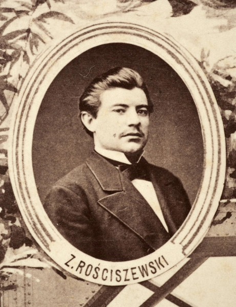 Fotografie w odcieniu sepii umieszczone na tle drzew i roślin, w centralnym miejscu postać kobiety ze sztandarem i aniołkami, wkomponowane widoki budowanej stacji, mostu kolejowego i lokomotywy. Największe zdjęcie w górnej, środkowej części bez podpisu, prawdopodobnie inż. głównej kolei nadwiślańskiej Tadeusz Chrzanowski lub jego następca Walery Titkow. Wśród podobizn pracownicy Biura Głównego Inżyniera: inż. Włodzimierz Stanisławski - pomocnik głównego inżyniera; inż. Feliks Kucharzewski -  pomocnik naczelnika biura; Feliks Kamocki - naczelnik kancelarii; Witold Lanci - naczelnik Wydz. Architektury; dr Wacław Lasocki- służba zdrowia; Władysław Radwan - sprawy zakupu gruntów; inż. Stanisław hr Scipio - projektant mostów kolejowych i jego współpracownicy: inż. Stefan Zieliński, inż. Maurycy Machalski, inż. Feliks Kucharzewski. Fotografia w passe - partout, za szkłem, oprawiona w drewnianą, profilowaną ramę.