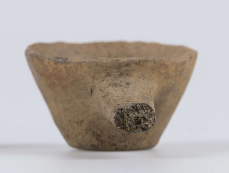 1702/A/ML - dno płaskie, ścianki proste, wylew zawinięty do wewnątrz; krawędź zaokrąglona; pod krawędzią umieszczono trzymadełko prostopadłe do ścianki, o przekroju owalnym, ułamane