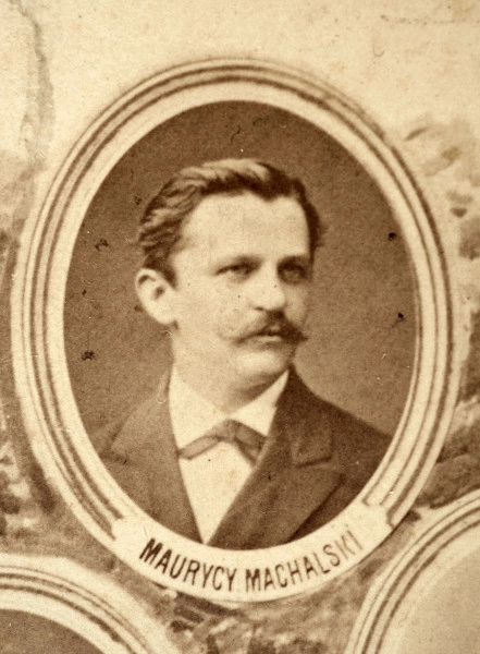 Fotografie w odcieniu sepii umieszczone na tle drzew i roślin, w centralnym miejscu postać kobiety ze sztandarem i aniołkami, wkomponowane widoki budowanej stacji, mostu kolejowego i lokomotywy. Największe zdjęcie w górnej, środkowej części bez podpisu, prawdopodobnie inż. głównej kolei nadwiślańskiej Tadeusz Chrzanowski lub jego następca Walery Titkow. Wśród podobizn pracownicy Biura Głównego Inżyniera: inż. Włodzimierz Stanisławski - pomocnik głównego inżyniera; inż. Feliks Kucharzewski -  pomocnik naczelnika biura; Feliks Kamocki - naczelnik kancelarii; Witold Lanci - naczelnik Wydz. Architektury; dr Wacław Lasocki- służba zdrowia; Władysław Radwan - sprawy zakupu gruntów; inż. Stanisław hr Scipio - projektant mostów kolejowych i jego współpracownicy: inż. Stefan Zieliński, inż. Maurycy Machalski, inż. Feliks Kucharzewski. Fotografia w passe - partout, za szkłem, oprawiona w drewnianą, profilowaną ramę.