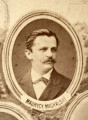 Fotografie w odcieniu sepii umieszczone na tle drzew i roślin, w centralnym miejscu postać kobiety ze sztandarem i aniołkami, wkomponowane widoki budowanej stacji, mostu kolejowego i lokomotywy. Największe zdjęcie w górnej, środkowej części bez podpisu, prawdopodobnie inż. głównej kolei nadwiślańskiej Tadeusz Chrzanowski lub jego następca Walery Titkow. Wśród podobizn pracownicy Biura Głównego Inżyniera: inż. Włodzimierz Stanisławski - pomocnik głównego inżyniera; inż. Feliks Kucharzewski -  pomocnik naczelnika biura; Feliks Kamocki - naczelnik kancelarii; Witold Lanci - naczelnik Wydz. Architektury; dr Wacław Lasocki- służba zdrowia; Władysław Radwan - sprawy zakupu gruntów; inż. Stanisław hr Scipio - projektant mostów kolejowych i jego współpracownicy: inż. Stefan Zieliński, inż. Maurycy Machalski, inż. Feliks Kucharzewski. Fotografia w passe - partout, za szkłem, oprawiona w drewnianą, profilowaną ramę.