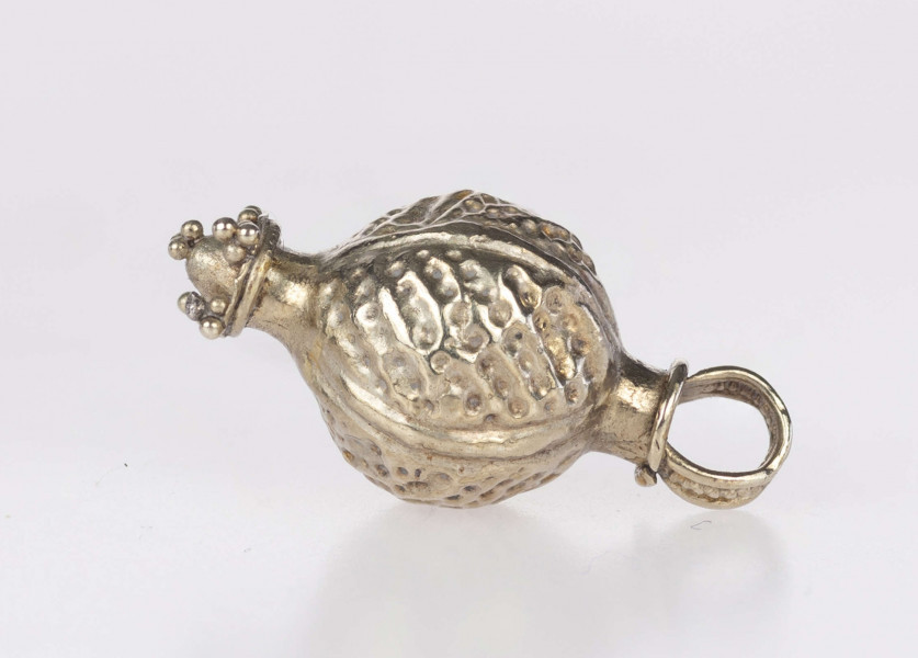 Wisiorek kulisty, typ Ia (wg. klasyfikacji A. v. Müllera). Korpus zdobiony czterema pionowymi żeberkami i wybijanymi punkcikami, wypełniającymi liniami w układzie skośnym pola pomiędzy nimi. Wieszadełko składające sie z szyjki przylegającej bezpośrednio do kuli, wieńczącego ją pierścienia i uszka taśmy z pogrubionym brzegiem z polem między nimi wypełnionym granulacją. Na dole wisiorka znajduje się element w postaci tulejki z przylutowanym stożkiem umieszczonym na profilowanej płyce, której narożniki, jak i szczyt stożka, zdobią triady granulek. Wisiorek prawdopodobnie był importem z terenów kultury wielbarskiej.
Wymiary dodatkowe: 2,5 mm (śr. szyjki wieszadełka); 2,5 mm (wys. szyjki wieszadełka); 4,0 mm (śr. pierścienia wieszadełka); 2,0 mm (szer. uszka); 2,0 mm (śr. tulejki); 1,5 mm (wys. stożka)