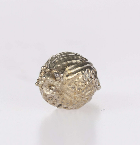 Wisiorek kulisty, typ Ia (wg. klasyfikacji A. v. Müllera). Korpus zdobiony czterema pionowymi żeberkami i wybijanymi punkcikami, wypełniającymi liniami w układzie skośnym pola pomiędzy nimi. Wieszadełko składające sie z szyjki przylegającej bezpośrednio do kuli, wieńczącego ją pierścienia i uszka taśmy z pogrubionym brzegiem z polem między nimi wypełnionym granulacją. Na dole wisiorka znajduje się element w postaci tulejki z przylutowanym stożkiem umieszczonym na profilowanej płyce, której narożniki, jak i szczyt stożka, zdobią triady granulek. Wisiorek prawdopodobnie był importem z terenów kultury wielbarskiej.
Wymiary dodatkowe: 2,5 mm (śr. szyjki wieszadełka); 2,5 mm (wys. szyjki wieszadełka); 4,0 mm (śr. pierścienia wieszadełka); 2,0 mm (szer. uszka); 2,0 mm (śr. tulejki); 1,5 mm (wys. stożka)