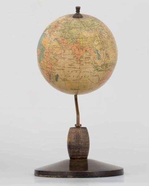 Mały polityczny globus Ziemi z polską nomenklaturą w skali 1:100 mln. Litografia kolorowa; 12 segmentów i 2 koła. Globus zamontowany na ramieniu drucianym, model 