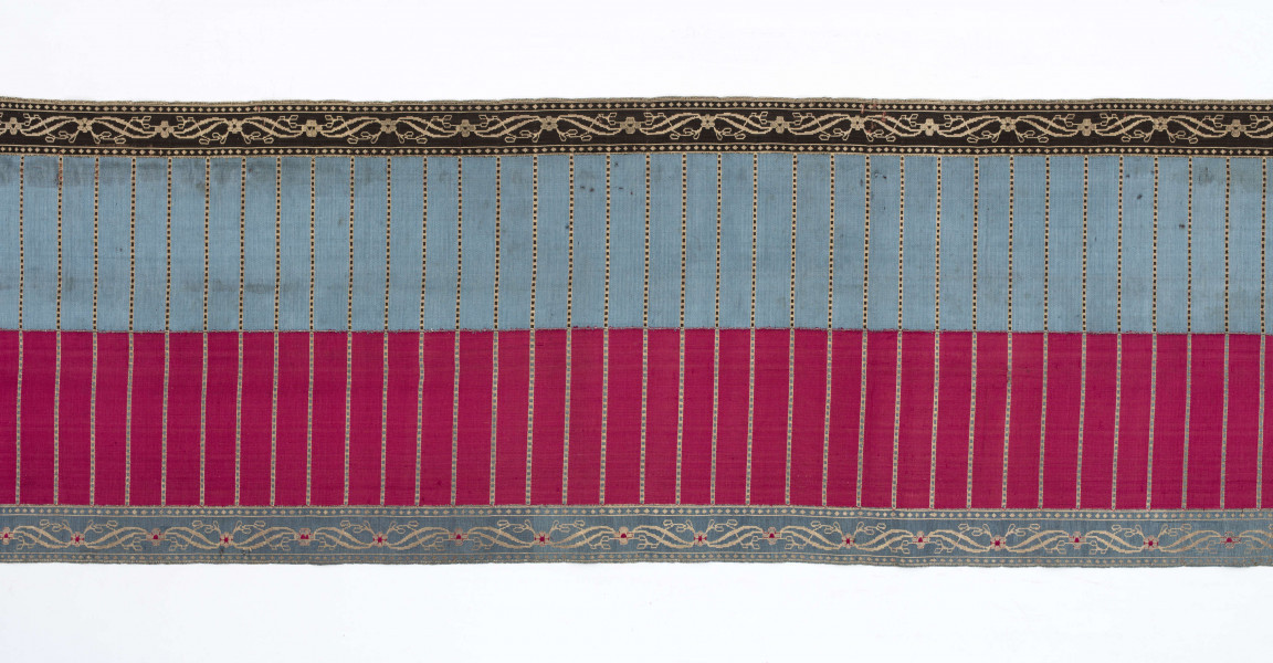 Pas kontuszowy 4-stronny
Ornament:
głowy - dwa krzaczki kwiatowe otoczone medalionami z wijącej się wstęgi
środek ( wciąż)- poprzeczne gładkie pólka
obwódki - z motywem kostki i rombów
obrzeżenia pionowe z motywem podwójnej przeplatającej się wici roślinnej, poziome - z motywem wijacej sie wstążki z kwiatami
Kolor:
pr. - tło głów i obrzeżeń srebrne, ornament brązowy z błękitem i amarantem, pólka w połowie brązowe (czarne ?), w połowie kremowe
l. - tło połowy głów i obrzeżeń błękitne oraz  w połowie pólek amarantowe, druga połowa głów i obrzeżeń brązowa oraz pólek - amarantowa
W narożnikach sygnatura wytkana 