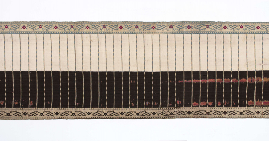 Pas kontuszowy 4-stronny
Ornament:
głowy - dwa krzaczki kwiatowe otoczone medalionami z wijącej się wstęgi
środek ( wciąż)- poprzeczne gładkie pólka
obwódki - z motywem kostki i rombów
obrzeżenia pionowe z motywem podwójnej przeplatającej się wici roślinnej, poziome - z motywem wijacej sie wstążki z kwiatami
Kolor:
pr. - tło głów i obrzeżeń srebrne, ornament brązowy z błękitem i amarantem, pólka w połowie brązowe (czarne ?), w połowie kremowe
l. - tło połowy głów i obrzeżeń błękitne oraz  w połowie pólek amarantowe, druga połowa głów i obrzeżeń brązowa oraz pólek - amarantowa
W narożnikach sygnatura wytkana 