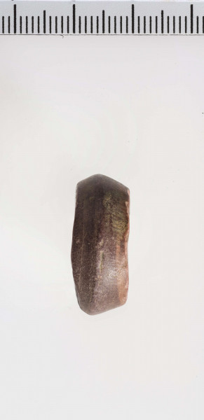 wykonany z łupka owruckiego; dwustożkowy, ostro profilowany; linia tworząca kształt dwustożkowy biegnie nieregularnie na różnych wysokościach; płasko ścięty przy otworze; otwór średniej wielkości, cylindryczny