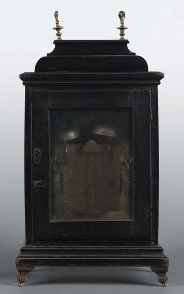 S/Mt/531/ML - Obudowa szafkowa, czworoboczna ze schodkowym zwieńczeniem, pokryta czarną politurą, oszklona z czterech stron, na czterech nóżkach z mosiądzu; w górnych narożnikach mosiężne sterczyny w formie płonących wazonów. Mechanizm chodu i bicia o napędzie sprężynowym, z wahadłem i dwoma dzwonkami; bicie godzin i kwadransów, budzik i repetier. Tarcza biało emaliowana z czarnymi cyframi arabskimi godzin i minut, w niej trzy otwory na osie sprężyn; trzy wskazówki, godzinowa i minutowa - ozdobne, sekundowa prosta. W górnej części tarczy sygnatura pisana ozdobną kursywą: M.G. / Jurkiewicz /  w Lublinie. Powyżej tarczy wycięcie z widocznym wahadełkiem kontrolnym i trzy mniejsze emaliowane tarcze: środkowa z miniaturą pejzażową, boczne z wyłączeniem chodu i bicia.