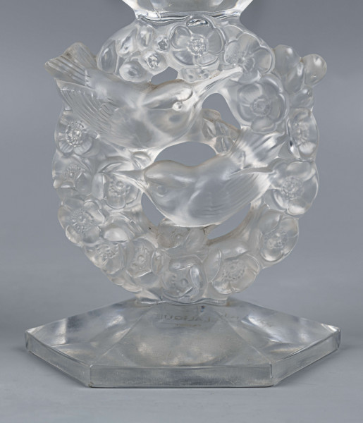 S/CS/1681/ML - Wazon w formie kielicha ze szkła bezbarwnego grubościennego; na sześciobocznej fasetowanej podstawie, trzon zdobiony plastycznie i matowiony w formie owalnego wieńca, wewnątrz którego siedzą dwa ptaszki - kolibry; czara koniczna fasetowana sześciobocznie z płaską krawędzią.
 