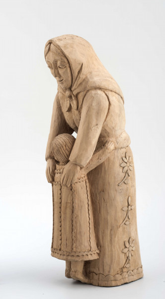 Rzeźba w drewnie lipowym, niepolichromowana, przedstawiająca postać kobiety nachylonej nad dzieckiem, stojącym przy kolanach. Kobieta w chustce na głowie zawiązanej pod brodą, o twarzy trójkątnej, dużych oczach, wąskich ustach. Ubrana w bluzkę z długimi rękawami i serdak z zaznaczoną baskinką , w długiej spódnicy pokrytej stylizowanymi wielopłatkowymi kwiatami na gałązce. U dołu biegnie pasek w formie falistej linii. Kobieta obejmuje rękami dziecko, zwrócone do niej twarzą. Dziecko z włosami sięgającymi do szyi, zaznaczonymi rowkowanymi nacięciami – uczesane z przedziałkiem  pośrodku. W długiej sukience, ozdobionej falistymi liniami poziomymi u dołu i góry, pionowymi pośrodku. 