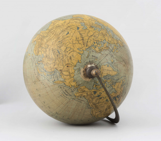 Globus fizyczny bez tytułu, roku wydania i granic politycznych. Kula tekturowa, oklejona mapą złożoną z 12 segmentów (każdy po 30 stopni) i 2 kół, postument drewniany, toczony, ozdobny, południk metalowy, 180-stopniowy, skalowany co 5 stopni, z zaznaczonymi zwrotnikami, równoleżniki zdobione, ruchomy.
Lądy - brak hipsometrii. Podstawowa sieć wodna i linia brzegowa kontynentów naznaczona na niebiesko. Powierzchnia kontynentów jest blado-żółta, poza białą Antarktydą. Na lądach zaznaczono rzeki, pustynie (sygnatura). Jeziora zakreskowano na ciemno-niebiesko. Największe góry oznaczono za pomocą metody kreskowej (w postaci 