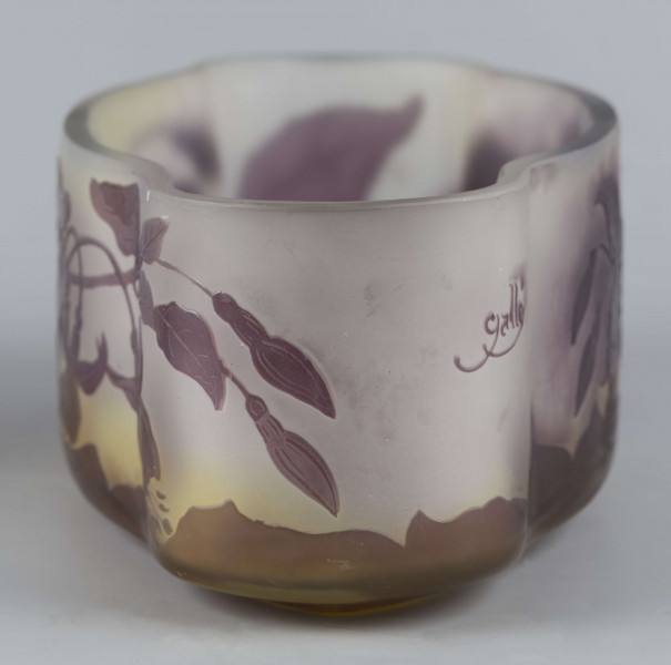 S/CS/1385/ML - Żardiniera ze szkła grubościennego, bezbarwnego, matowanego, podbarwianego żółtym i liliowym pudrem; na niskiej spiczasto-owalnej podstawie korpus o ściankach pionowo sfalowanych, u dołu lekko zaokrąglony, górna krawędź ścięta. Korpus pokryty warstwą liliową, w niej trawiony wzór roslinny: gałązka fuksji z kwiatami, przy dnie dookoła  pasmo liliowe o nieregularnym wykroju.
 