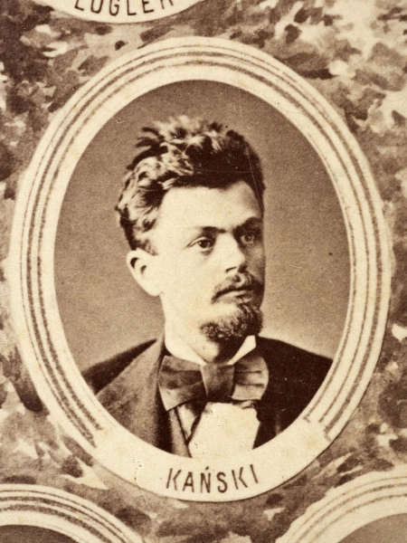 Fotografie w odcieniu sepii umieszczone na tle drzew i roślin, w centralnym miejscu postać kobiety ze sztandarem i aniołkami, wkomponowane widoki budowanej stacji, mostu kolejowego i lokomotywy. Największe zdjęcie w górnej, środkowej części bez podpisu, prawdopodobnie inż. głównej kolei nadwiślańskiej Tadeusz Chrzanowski lub jego następca Walery Titkow. Wśród podobizn pracownicy Biura Głównego Inżyniera: inż. Włodzimierz Stanisławski - pomocnik głównego inżyniera; inż. Feliks Kucharzewski -  pomocnik naczelnika biura; Feliks Kamocki - naczelnik kancelarii; Witold Lanci - naczelnik Wydz. Architektury; dr Wacław Lasocki- służba zdrowia; Władysław Radwan - sprawy zakupu gruntów; inż. Stanisław hr Scipio - projektant mostów kolejowych i jego współpracownicy: inż. Stefan Zieliński, inż. Maurycy Machalski, inż. Feliks Kucharzewski. Fotografia w passe - partout, za szkłem, oprawiona w drewnianą, profilowaną ramę.